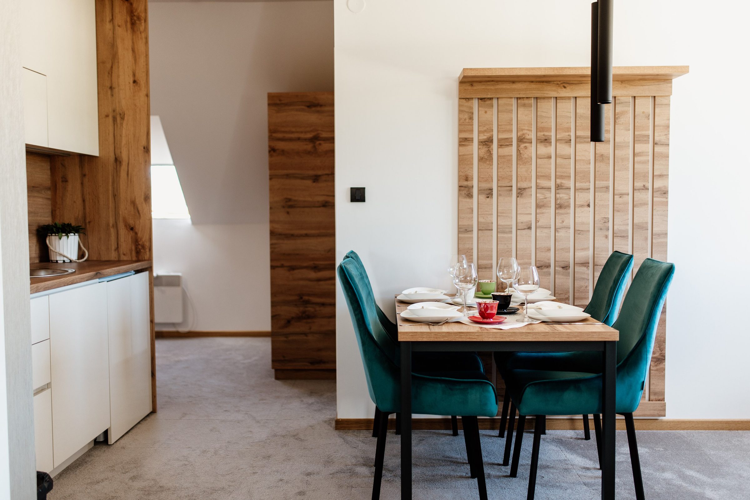The long table laid for dinner against a slatted oak screen